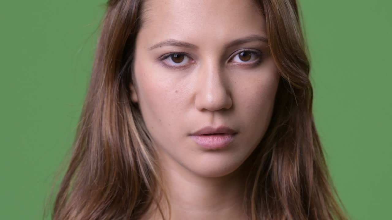 Ung vacker kvinna med flera etniska bakgrunder mot grön bakgrund.