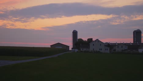 sunrise over amish farmlands with a colorful sky on a misty summer morning timelapse