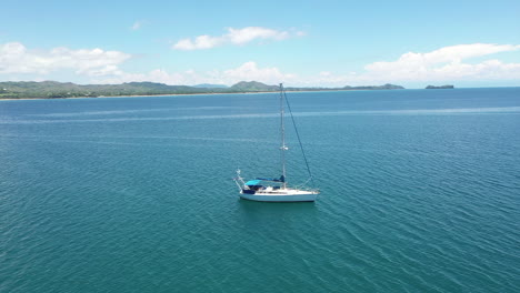 Toma-Aérea-Giratoria-De-Un-Velero-En-Un-Océano-Azul-Frente-A-La-Costa-De-Madagascar