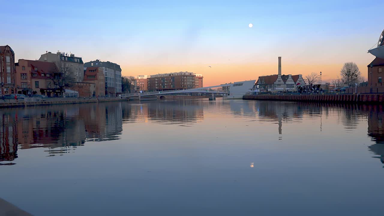 foto panorámica de la hora dorada del paisaje urbano junto al río y el puente peatonal en el fondo ta gdansk polonia