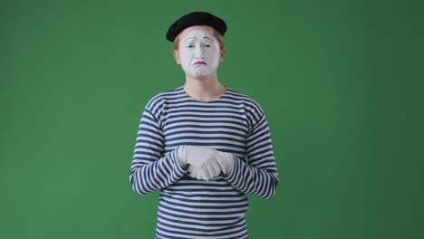 mime artist crying over green background