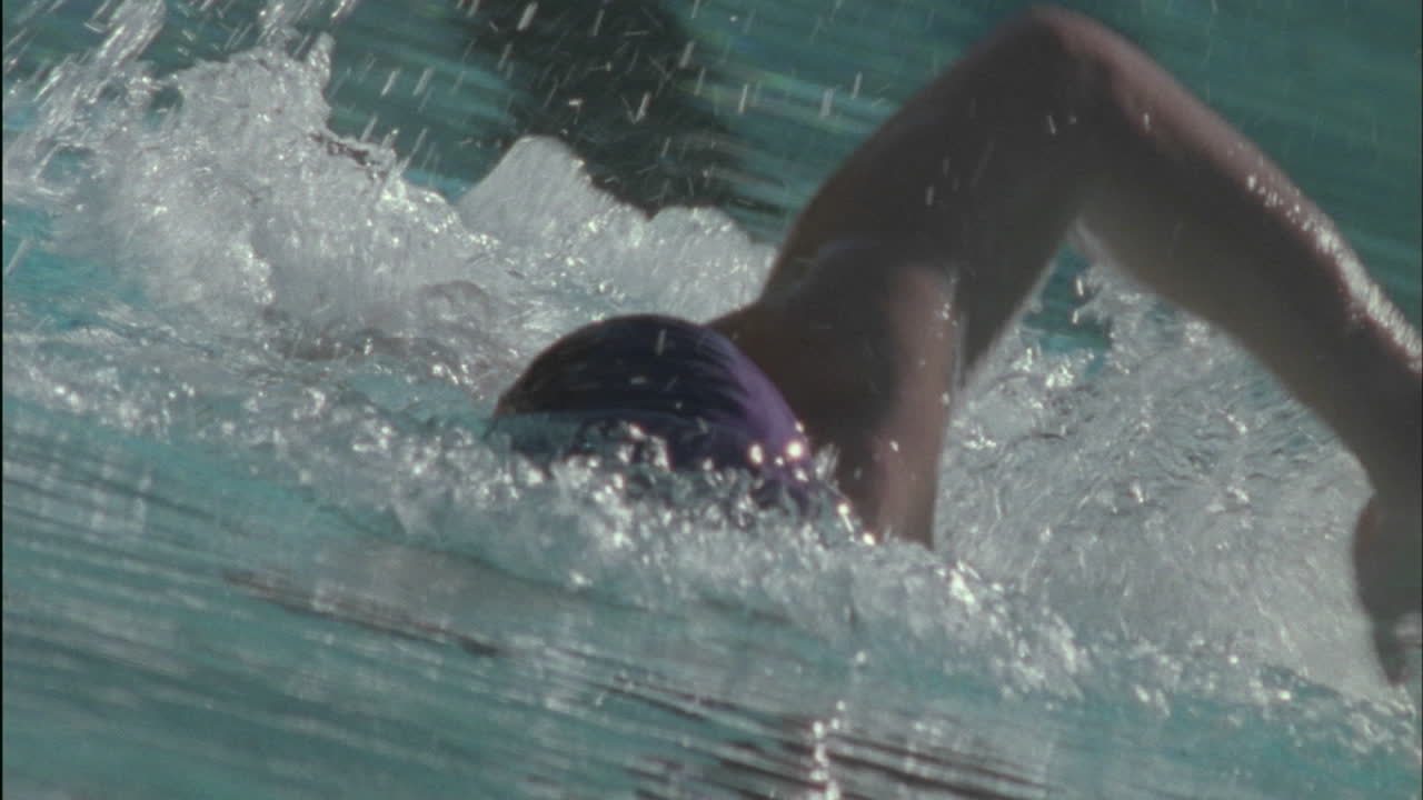 A man swims to the other side of a pool