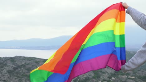 a lgtb flag being waved outdoors