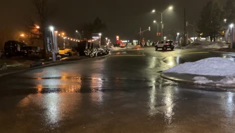 Eisiger-Regen-In-Der-Nacht-Im-Winter-Mit-Schmelzendem-Schnee-Und-Nassen-Straßen-Mit-Vorbeifahrenden-Autos-Und-Straßenlaternen,-Die-Die-Straßen-Und-Die-Umgebung-Bei-Regnerischem,-Schlechtem-Wetter-Und-Leichtem-Nebel-Beleuchten