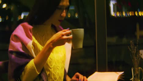 woman enjoying a warm drink and dessert at a cozy night cafe