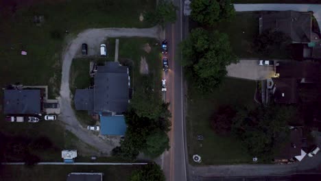 aerial bird's eye view over police suv vehicles with flashing red and blue lights has pulled over a car for speeding during evening time