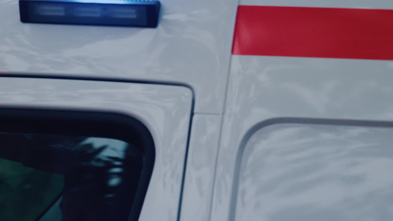 Chisinau, Moldova - October 1, 2025: Emergency ambulance driving through a city street with flashing blue lights during dusk