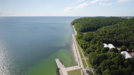 aerial bastic sea coastline with a view of feliks nowowiejski seaside boulevard lealing to the gdynia city public beach by dense forestery green park