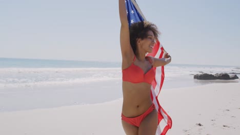 mujer joven bailando con bandera en la playa 4k