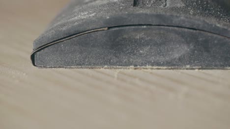 man putting down a hand sanding block forming a sawdust cloud