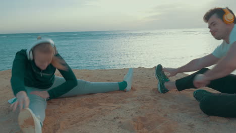 young man and woman exercising by the sea