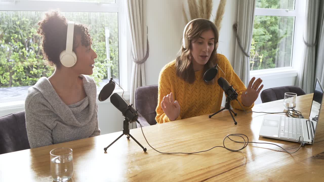Diverse co-conduttrici parlano in studio usando microfoni per un podcast.