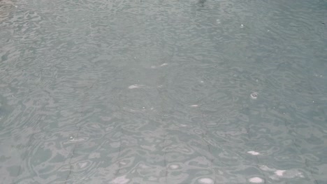 rain drop just sprinkling over swimming pool.