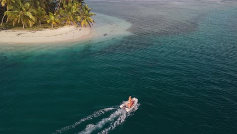 Toma-De-Drone-Al-Atardecer-De-3-Jóvenes-En-Un-Bote-En-Las-Islas-De-San-Blas,-Panamá