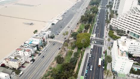 4k drone shot of ocean avenue and pacific coast highway in santa monica, los angeles, california with the ocean and santa monica beach in the background