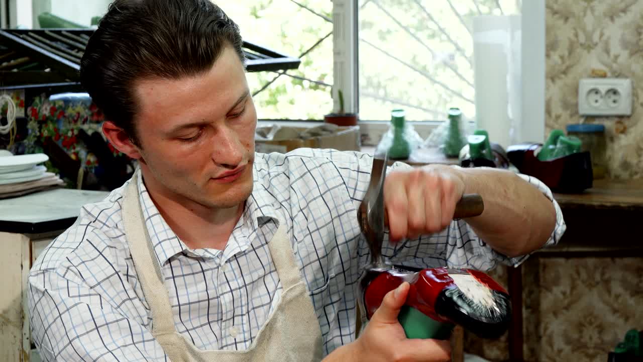 Ein attraktiver junger Schuhmacher in seiner Werkstatt.