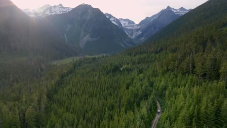 driving to pemberton in duffey lake road passing by forested landscape and snow mountain ridge in british columbia, canada