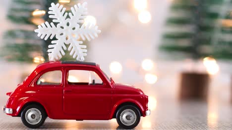 mini coche rojo con copo de nieve en el techo y luces parpadeantes detrás