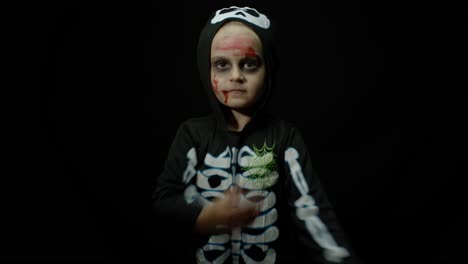 Halloween-angry-girl-with-blood-makeup-on-face.-Kid-dressed-as-scary-skeleton,-dancing,-making-faces