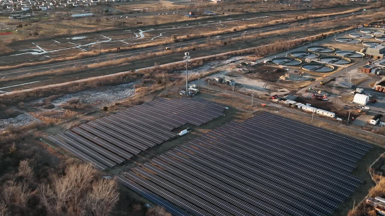 вид с воздуха на множество больших солнечных батарей в солнечный день