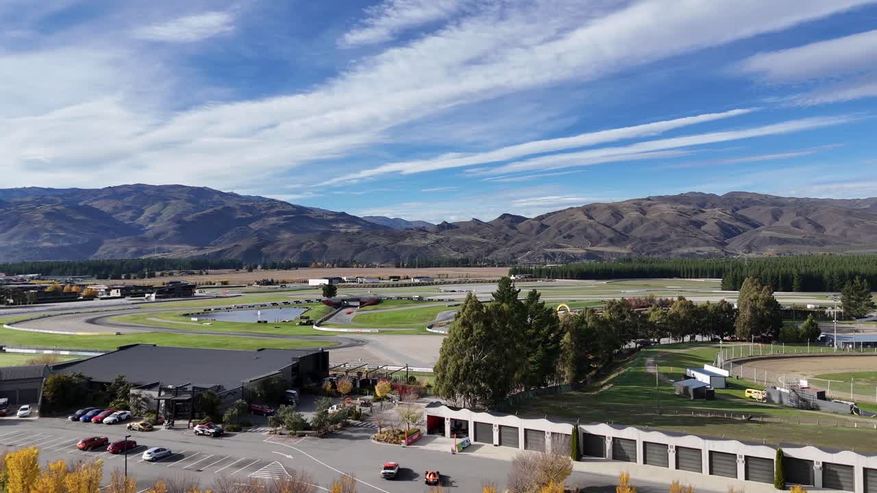 Aerial footage of Highlands Motorsport Park in Queenstown, New Zealand. Captures vibrant autumn colors and expansive mountain views