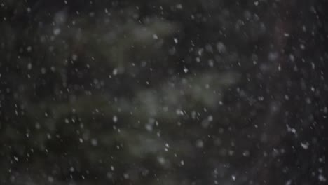 Slow-motion-shot-of-snow-falling-with-a-dark-blurry-background