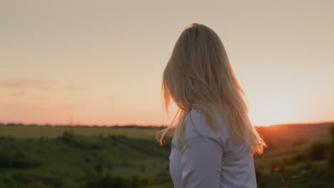 woman playing with her long hair at sunset