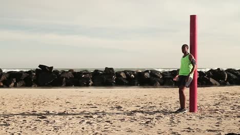 man taking a break from running on the beach