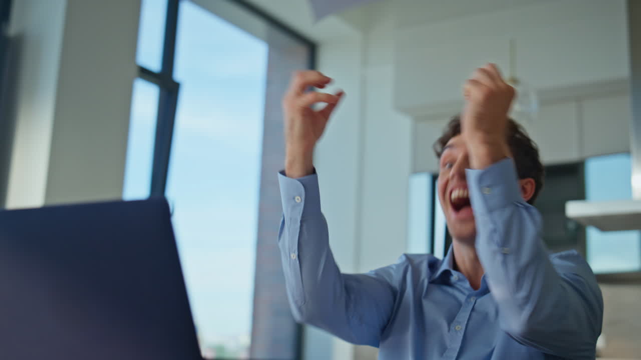 Entrepreneur rejoicing success reviewing documents at desk with laptop closeup
