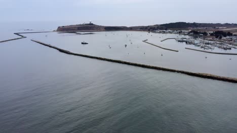 aérea: vista de dron, costa, punto de pilar y barcos, volando hacia adelante