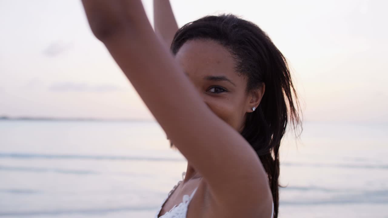 Ritratto di una ragazza afroamericana su una spiaggia oceanica.