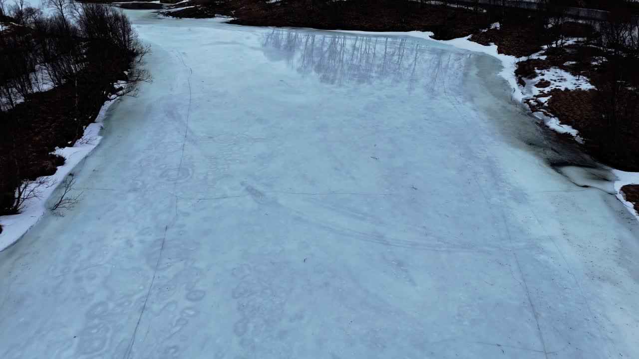 Frozen river surface with ice cracks in Otertinden, Norway, during winter season