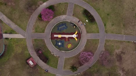 aerial top down view of a circular playground for children inside a park