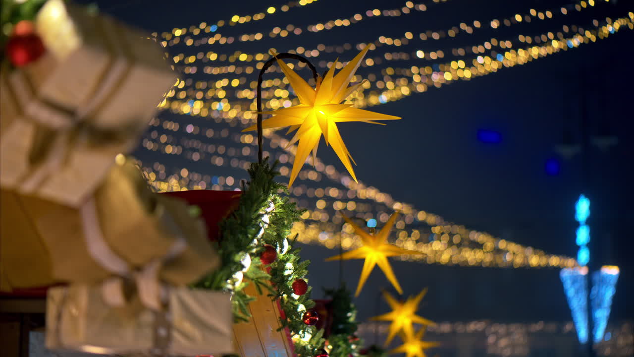 Close up of a Christmas garland on a market boutique with blurry lights on the background