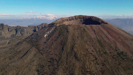 Vista-Aérea-Orbitando-El-Pico-Del-Monte-Vesubio,-Sur-De-Italia-Bajo-Un-Cielo-Azul-Soleado