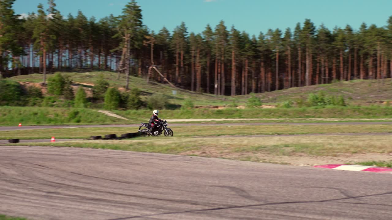 motociclista probando sus habilidades en la pista de carreras local, vista de seguimiento en cámara lenta