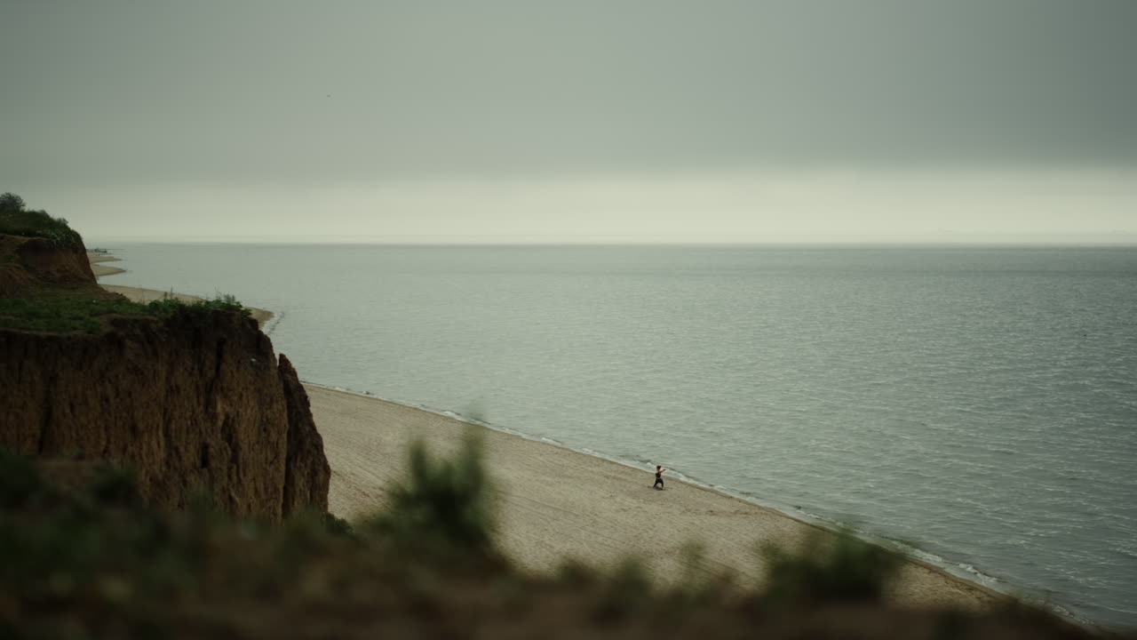 hermosa vista de colinas verdes cerca del océano tranquilo. paisaje playa de arena día nublado.