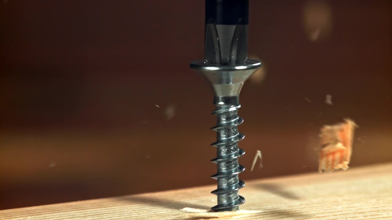 Slow Motion Shot of a Screw Fastening into a Wooden Plank