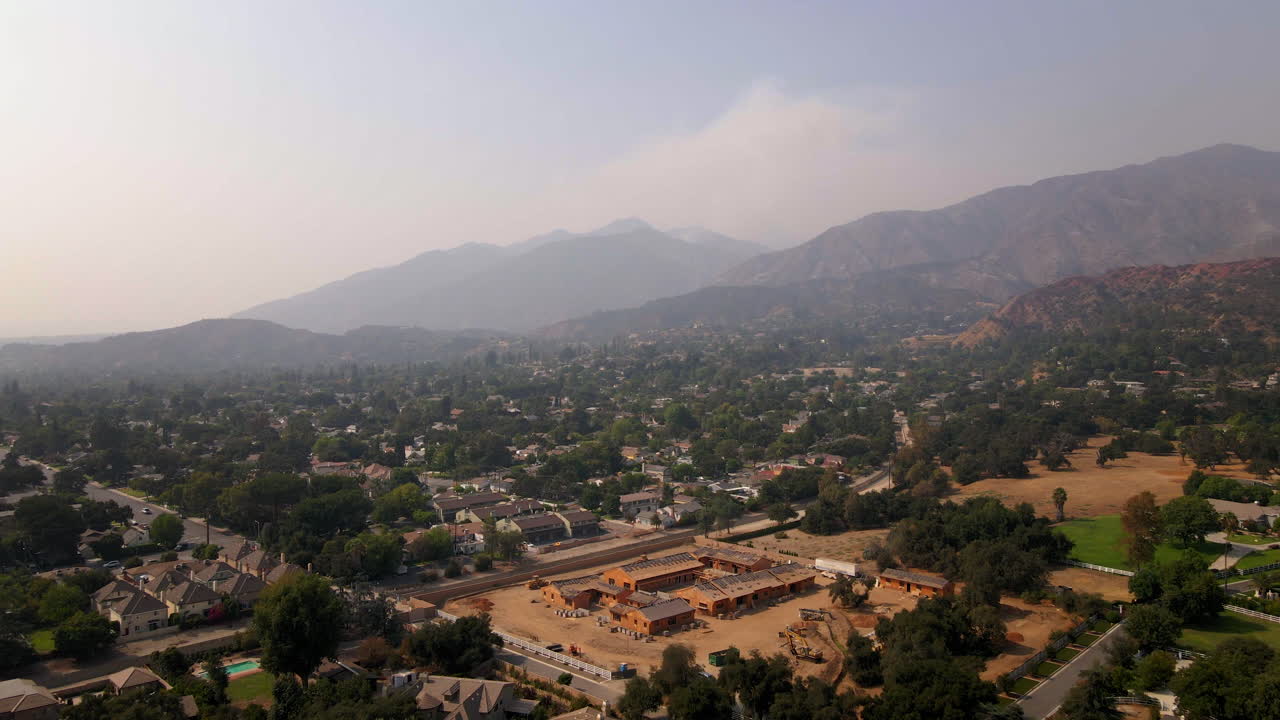 Aerial View of Suburban Development Under Hazy Skies with Distant Mountains