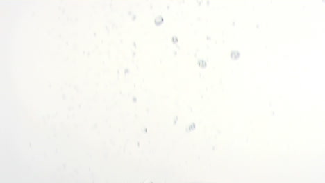 animation of uncut diamonds falling and red confetti floating up, on white background