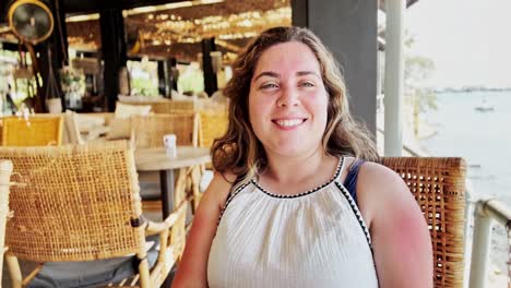 greek summer day: woman at marina cafe table