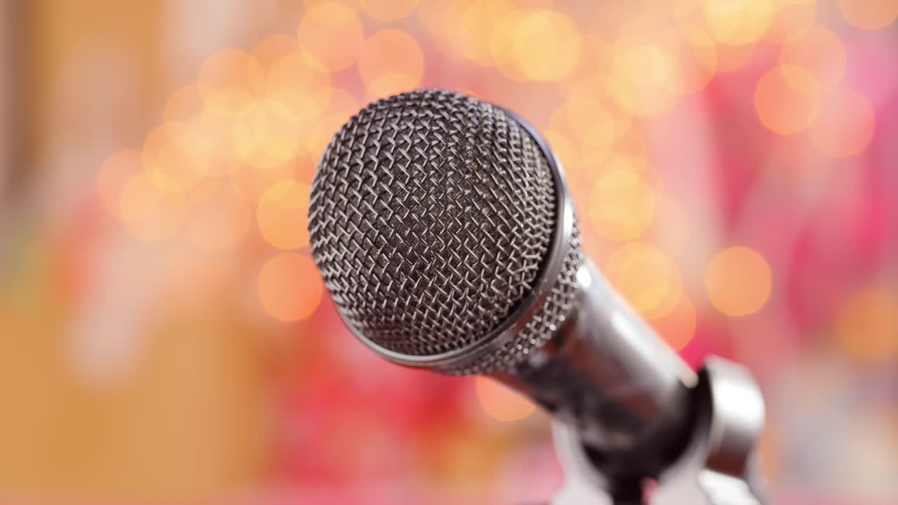 Microphone on stage against a blurry light ,blurry background.