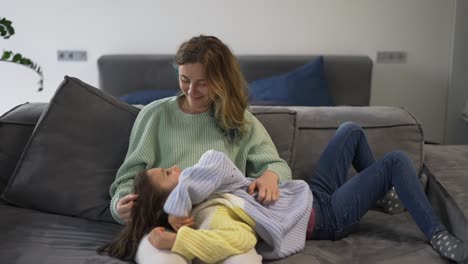 Mother-and-small-daughter-bonding-together-on-the-sofa