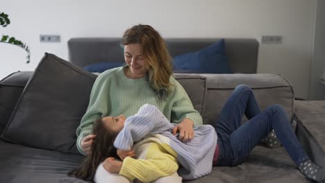 mother and small daughter bonding together on the sofa