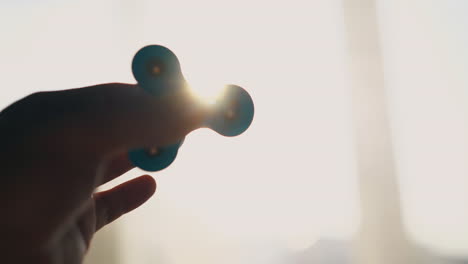 young-man-plays-with-spinner-against-bright-sunlight