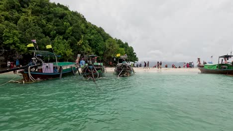 barcos y turistas en una playa tropical