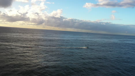 A-small-boat-travels-across-the-ocean-during-an-early-morning-sunrise-near-Bondi-Australia