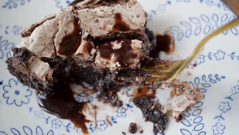 Tenedor-Tomando-Un-Bocado-De-Una-Rebanada-De-Postre-De-Brownie-Horneado-Cubierto-Con-Merengue-Y-Rociado-Con-Sirope-De-Chocolate