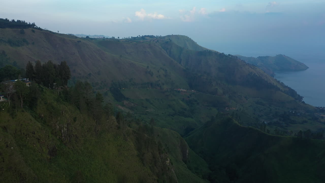 Rekaman drone udara lembah hijau dan tebing di atas Danau Toba di Kabupaten Karo, Sumatera Utara, Indonesia.