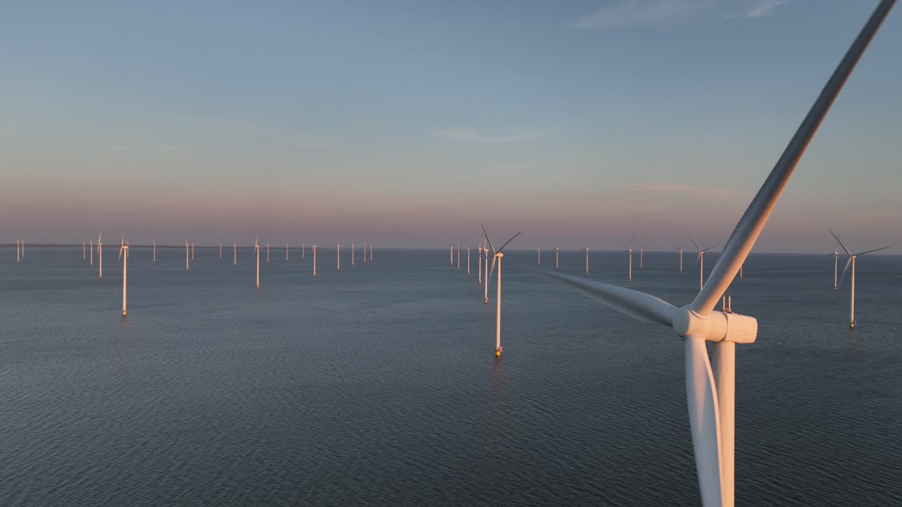Wind turbines, close up, aerial view, Clean energy on water, offshore, wind park, sunset. Climate change solution. Aerial view.